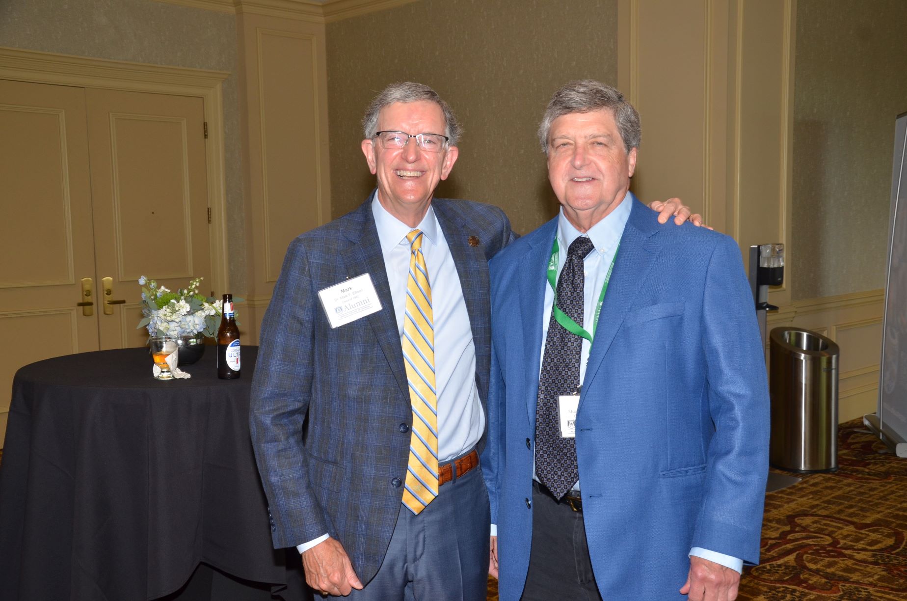 two alumni posing for a photo